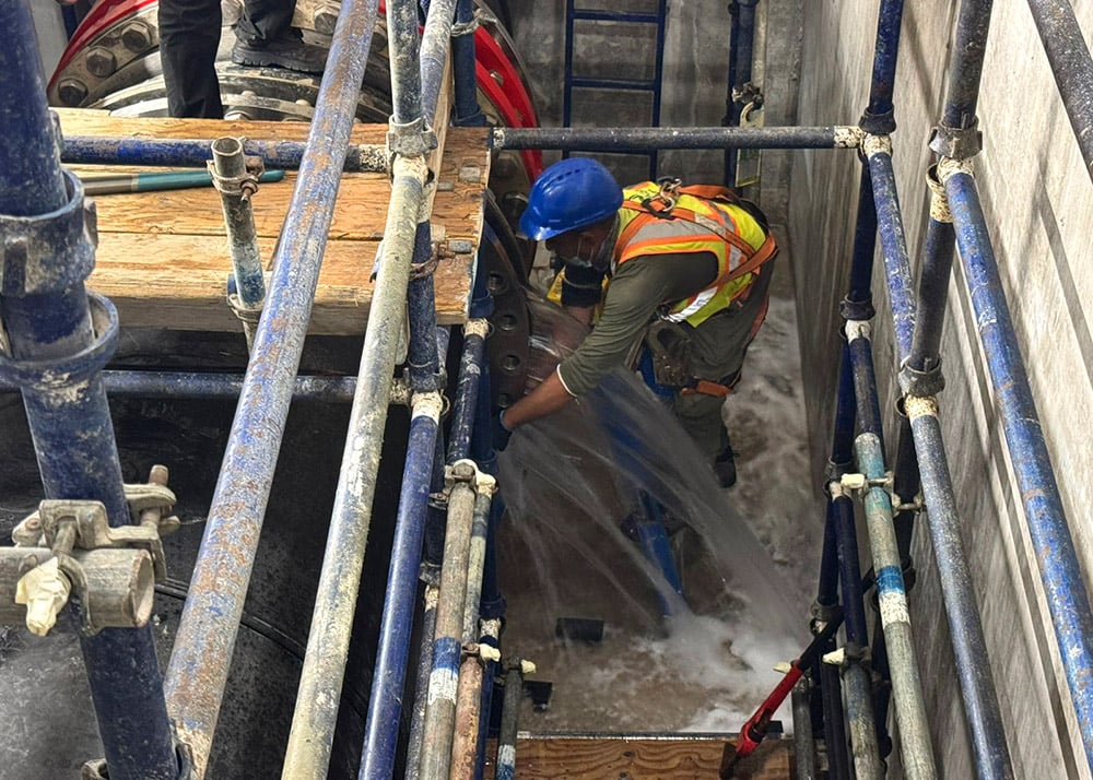 Confined waterpark basin during maintenance, showing limited working space with central pipeline